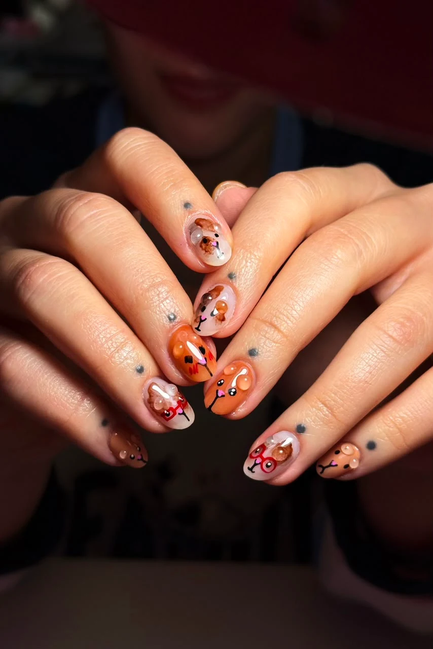 Diseño de uñas con ilustraciones en tonos cálidos.
