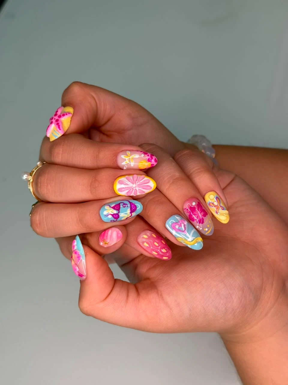 Gel semipermanente con diseños coloridos en tonos rosa, azul y amarillo.